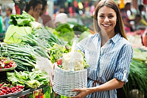 Young woman buying vegetables at the market.