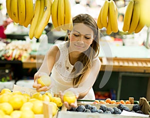 Young woman buys fruit at the market