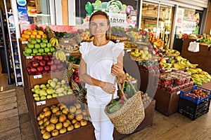 a young woman buys fruits and vegetables at a market. fresh and healthy food.