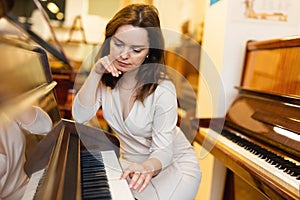 Young woman buys pianoforte in a music store