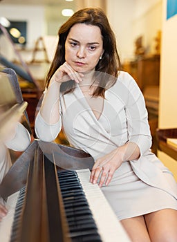 Young woman buys pianoforte in a music store photo