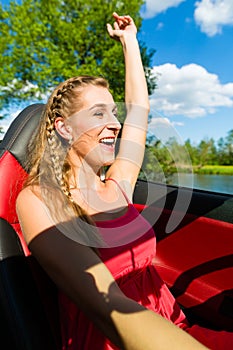 Young woman with cabriolet in summer on day trip