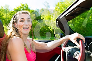 Young woman with cabriolet in summer on day trip