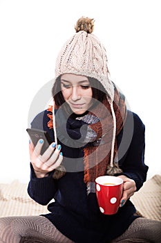 Young woman at cafe drinking coffee and talking or sms on the mobile phone