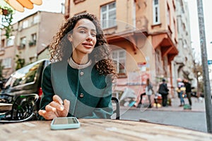 Young woman in a cafe reading a message from her mobile phone