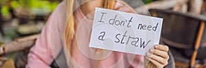 Young woman in a cafe shows a sign - I don't need a straw. No plastic. Global environmental protection issue BANNER