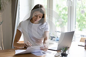 Young woman calculate manage finances using laptop