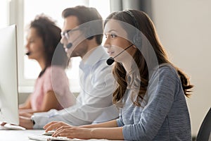 Young woman call center agent in headset consulting online client