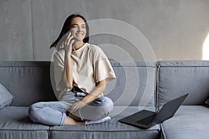 Happy young woman caller talking on the phone at home