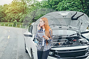 Young Woman calling for assistance with his car broken down by t