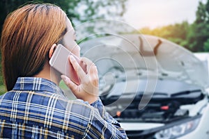 Young Woman calling for assistance with his car broken down by t