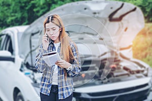 Young Woman calling for assistance with his car broken down by t