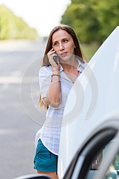 Young woman calling assistance about troubles with her car