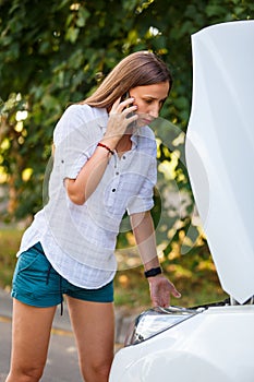 Young woman calling assistance about troubles with her car