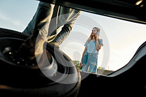 Young woman calling car service or assistance while having troubles with her car, Close up of hands of man taking out