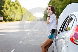 Young woman calling for help at the broken car