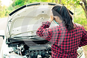 young woman calls insurance while the car is broken