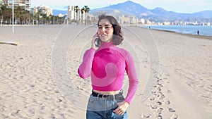 Young woman calls on the phone and walks along the sea