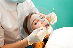 Young woman came to the dentist for examination. The dental doctor examines the patient close-up