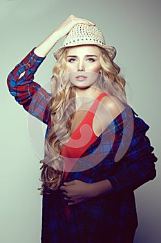 Young woman with camera. Blonde in a plaid shirt. Hipster fashion