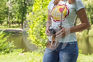 Young woman with camera outdoors . Soft sunny colors. woman with vintage retro camera