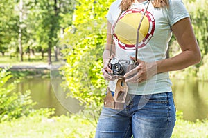 Young woman with camera outdoors . woman with vintage retro camera