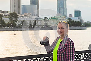 Young woman with a camera on the promenade