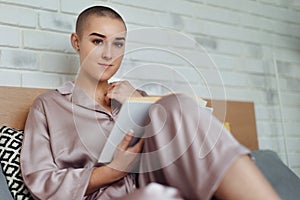 Young woman with cancer reading book, cancer awareness concept.