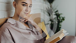 Young woman with cancer reading book, cancer awareness concept.