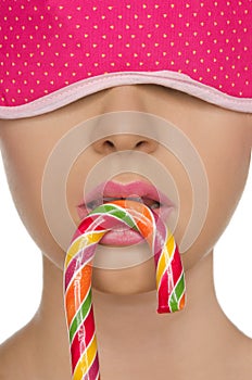 Young woman with candy in his mouth and blindfold