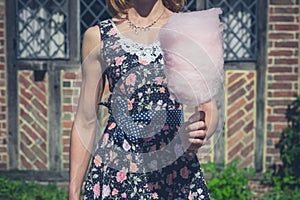 Young woman with candyfloss outside