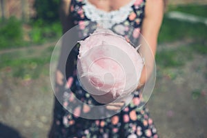 Young woman with candyfloss outside