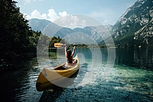 Young woman canoeing in the lake bohinj on a summer day