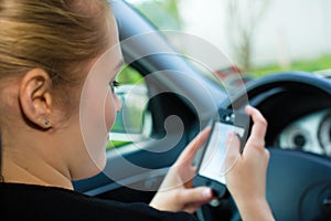 Young woman, in car with mobile phone