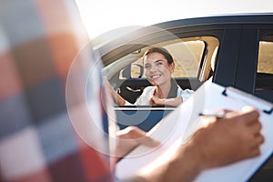 Young woman in car near her instructor outdoors. Driving school