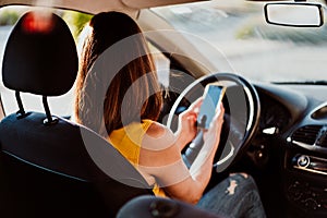 Young woman in a car using mobile phone, wearing protective mask. Summer season. prevention corona virus concept