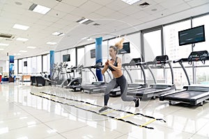 Young woman cardio exercising jumping at gym fitness center