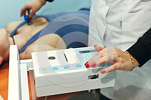 Young woman cardiologist doctor measuring heart with modern medical equipment stethoscope in hospital, health check-up of strong