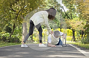 young woman caregiver is helping disability senior man fall due to practice walking with a walker