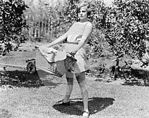 Young woman carrying a basket of laundry