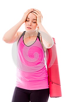 Young woman carrying exercising mat looking depressed