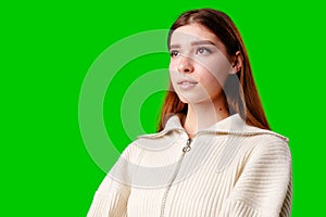 Young Woman in Casual Attire Posing Against Vivid Green Background in Studio Setting