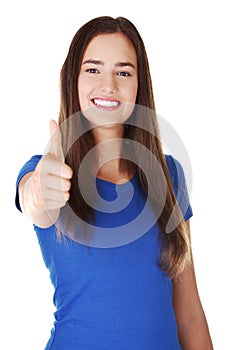 Young woman in casual clothes gesturing thumbs up.