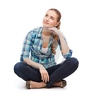 Young woman in casual clothes sitting on floor