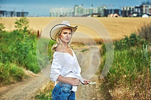 Young woman in casual clothes for a walk in a field of wheat