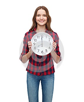 Young woman in casual clothes with wall clock