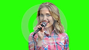 Young woman in casual wear singing in microphone.