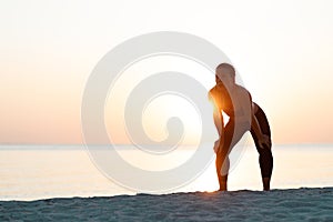 Young woman catching a breath after a run on the beach