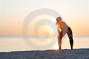 Young woman catching a breath after a run on the beach