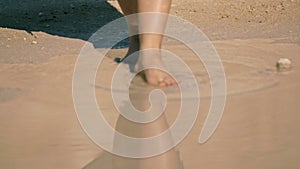 Young woman cautiously enters the lake water. body part,